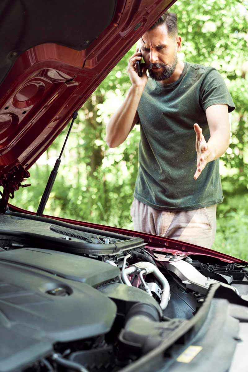 Junger Mann prüft Getriebeschaden bei Schrottauto Ankauf Segeberg